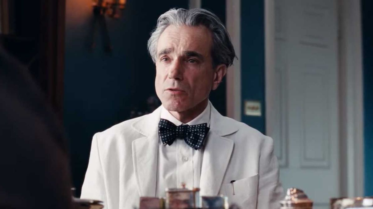 Daniel Day-Lewis with gray hair, wearing a white suit and bow tie, with a serious expression, marking his return to acting in "Anemone."