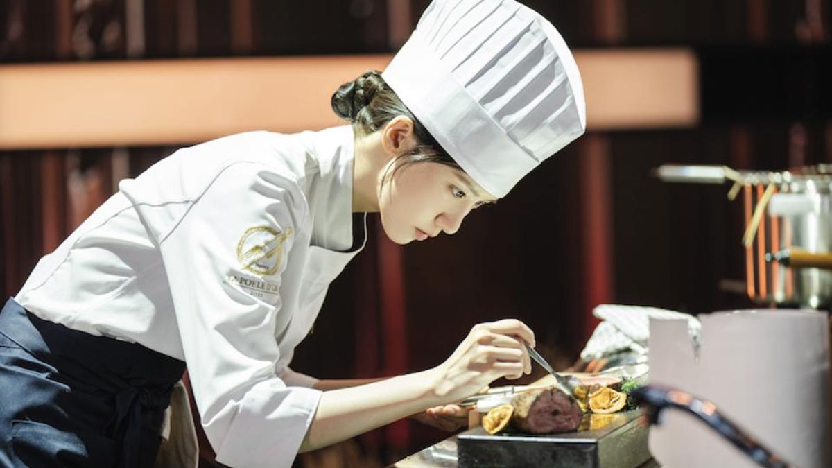 Yoona as Yeon Ji-yeong, a chef, meticulously plating a dish in a modern kitchen setting, demonstrating her professional cooking skills.