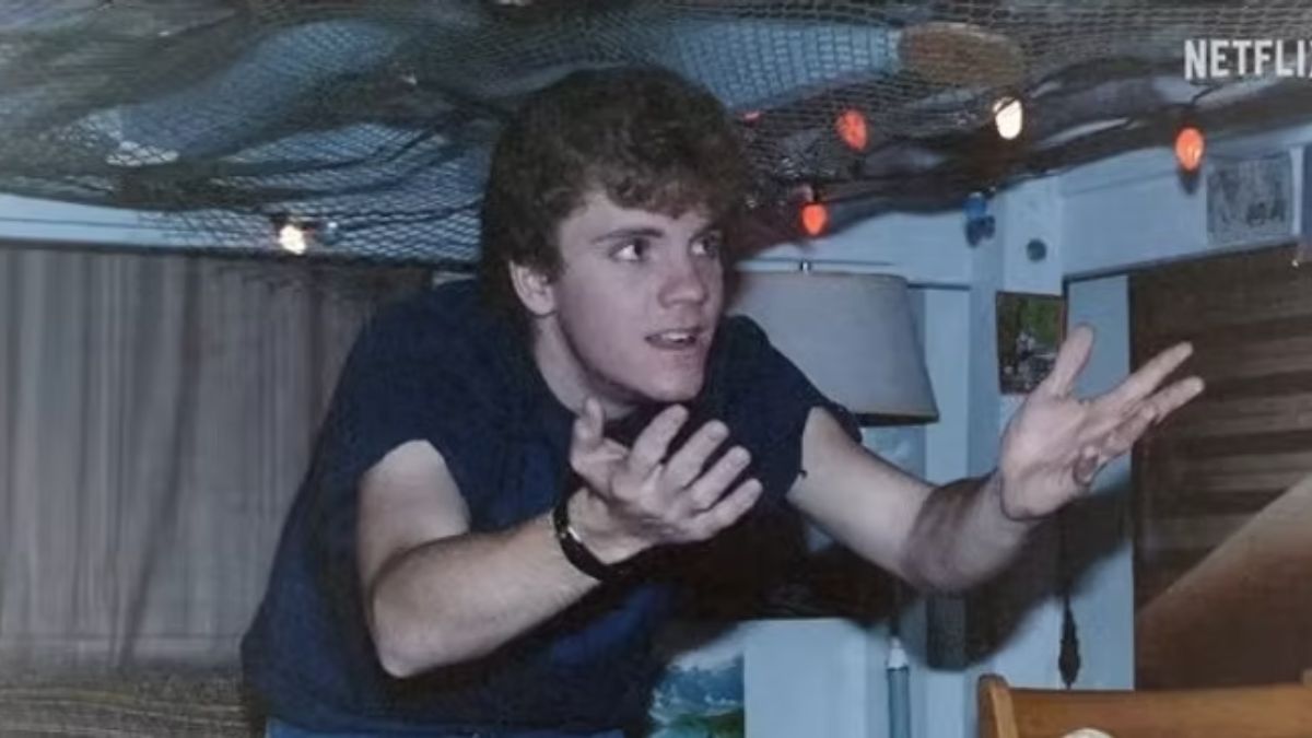 A young man in distress, gesturing widely and talking in a dimly lit, cluttered room, symbolizing a chilling paranormal experience.