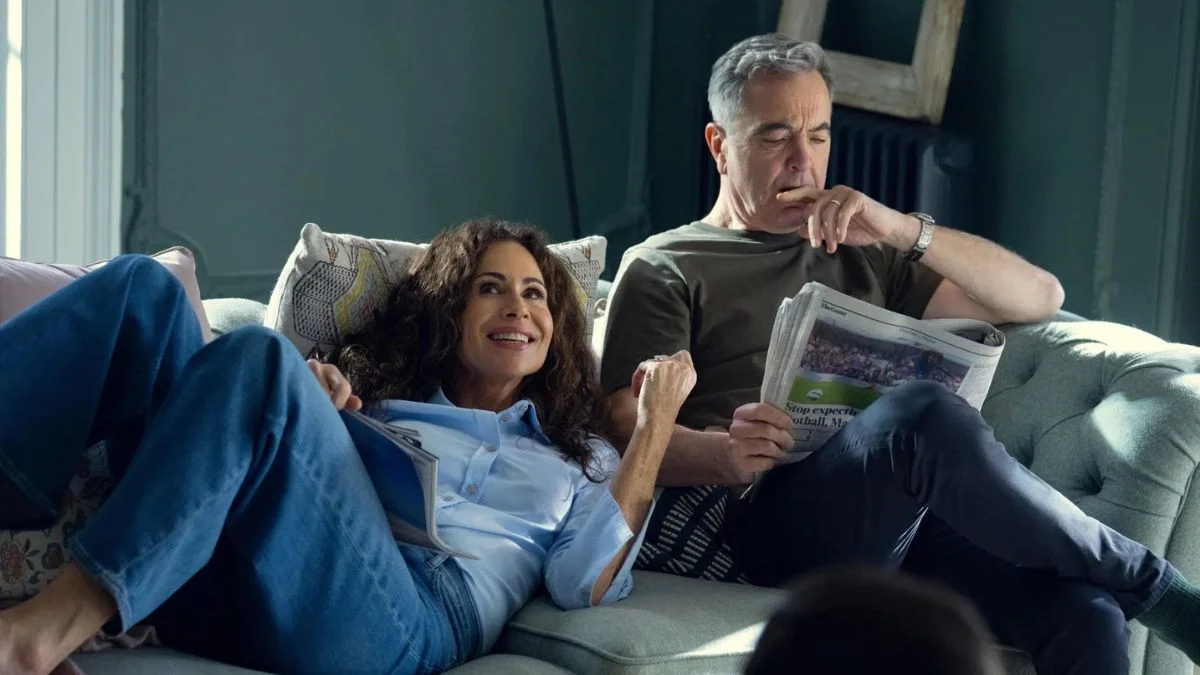 James Nesbitt as Simon Greene and Minnie Driver as Ingrid Greene sitting on a sofa in a scene from Netflix's Run Away.