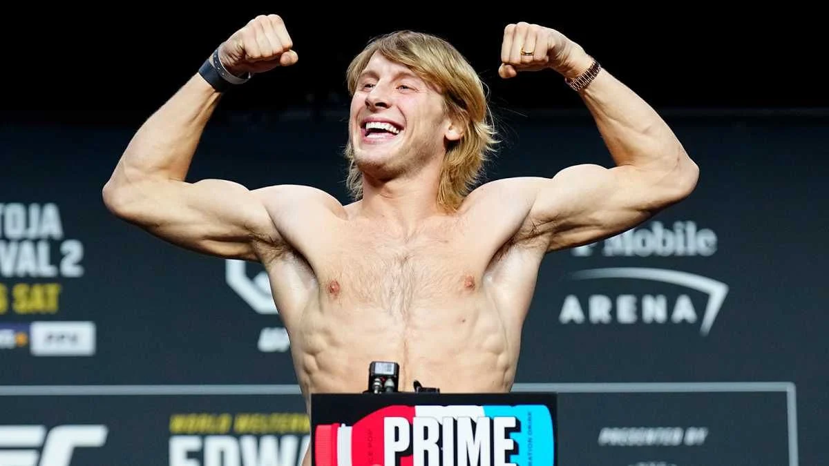 UFC fighter Paddy Pimblett flexing his muscles and smiling during a weigh-in at the T-Mobile Arena.