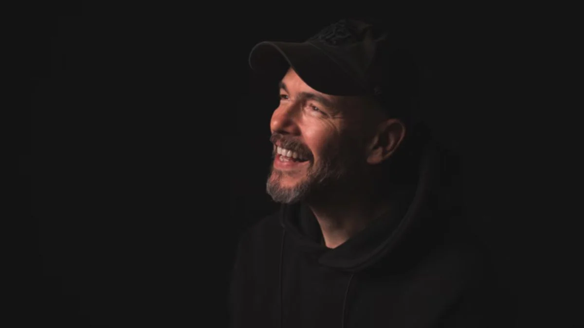 Julian Gerighty, former creative lead of The Division at Ubisoft, smiling in a dark setting.