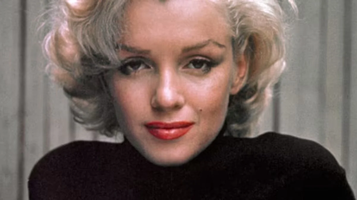 Close-up portrait of Marilyn Monroe wearing a black turtleneck with a soft, melancholy expression.