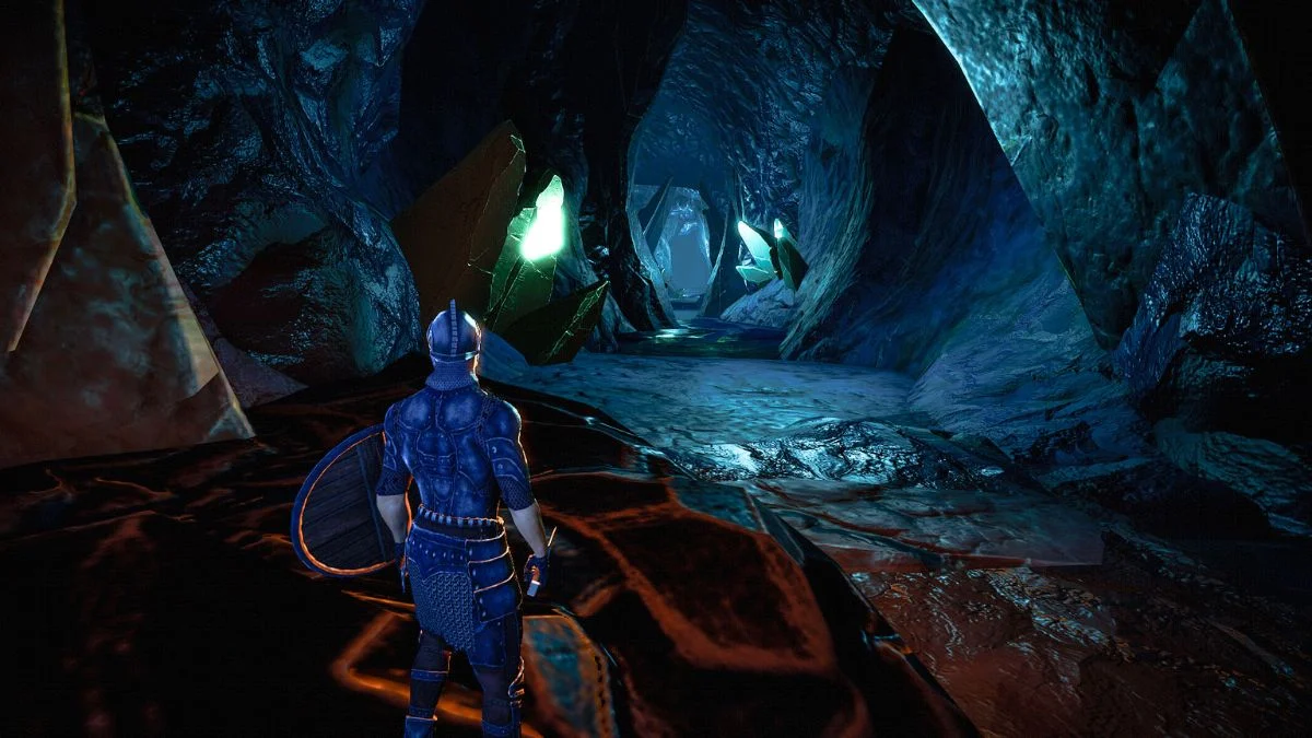 A third-person view of a player character in metal armor with a shield, standing in a dark cave illuminated by glowing green crystals.