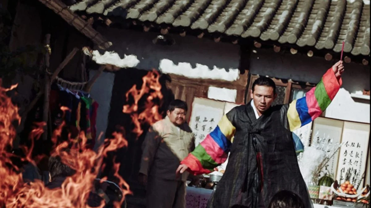 Shaman Il-gwang performing an intense exorcism ritual with fire and traditional robes.