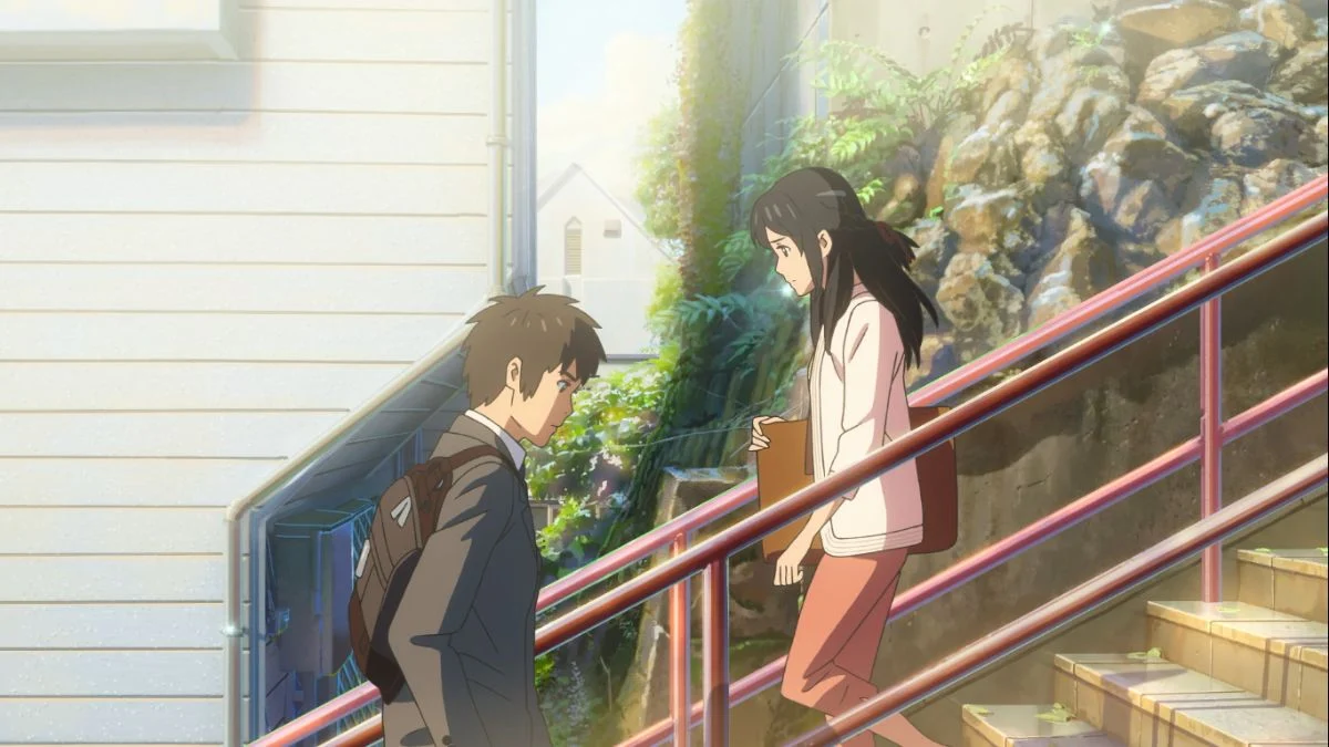 Taki and Mitsuha pass each other on the red-railed Suga Shrine staircase in Tokyo during the final scene of the anime Your Name.
