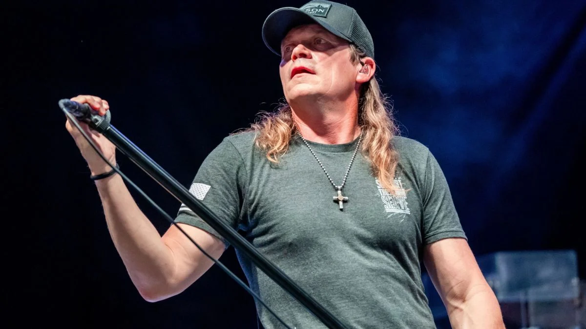 Lead singer Brad Arnold of 3 Doors Down performing live on stage with a microphone.