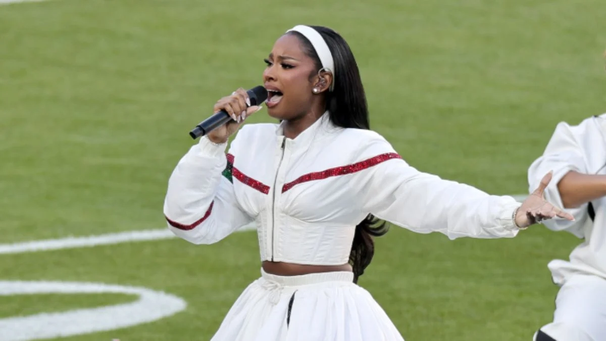 Coco Jones performing Lift Every Voice and Sing in a white tracksuit at Super Bowl LX.