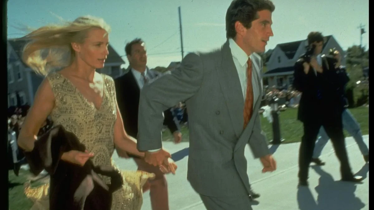 John F. Kennedy Jr. and Daryl Hannah running together in a formal suit and sequined dress.