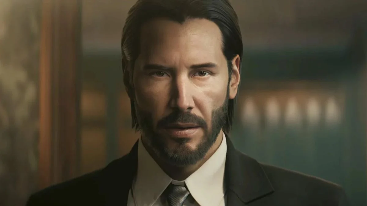 A close-up digital render of Keanu Reeves as John Wick from the upcoming Saber Interactive video game, showing his iconic beard and suit.