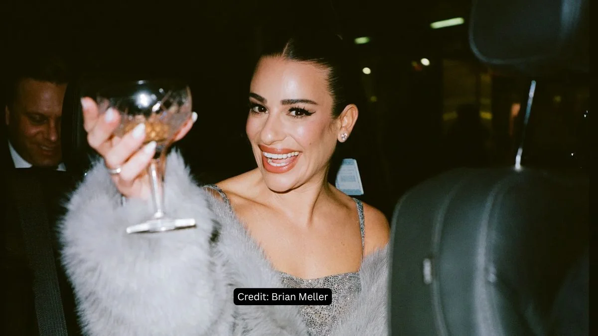 Lea Michele smiling and holding a glass backstage at the Broadway opening of Chess.