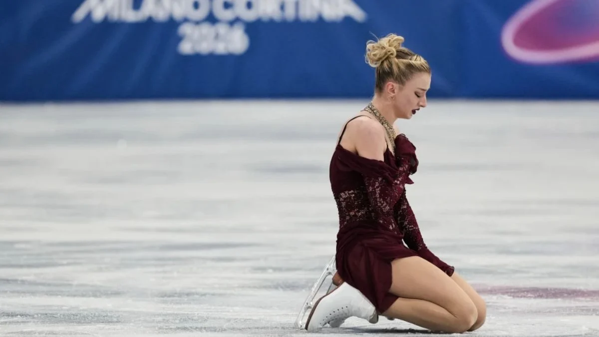 Figure skater Amber Glenn reacting with shock and joy while watching a surprise video message from Madonna before her 2026 Winter Olympics short program.