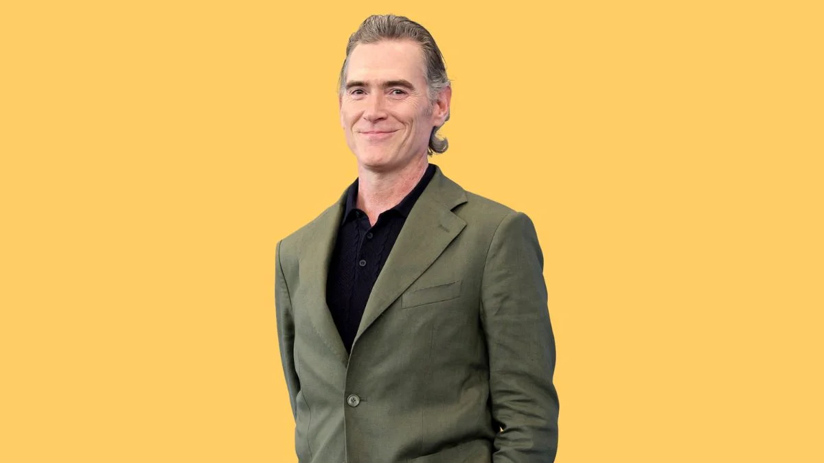 Billy Crudup wearing a green suit jacket against a yellow background.