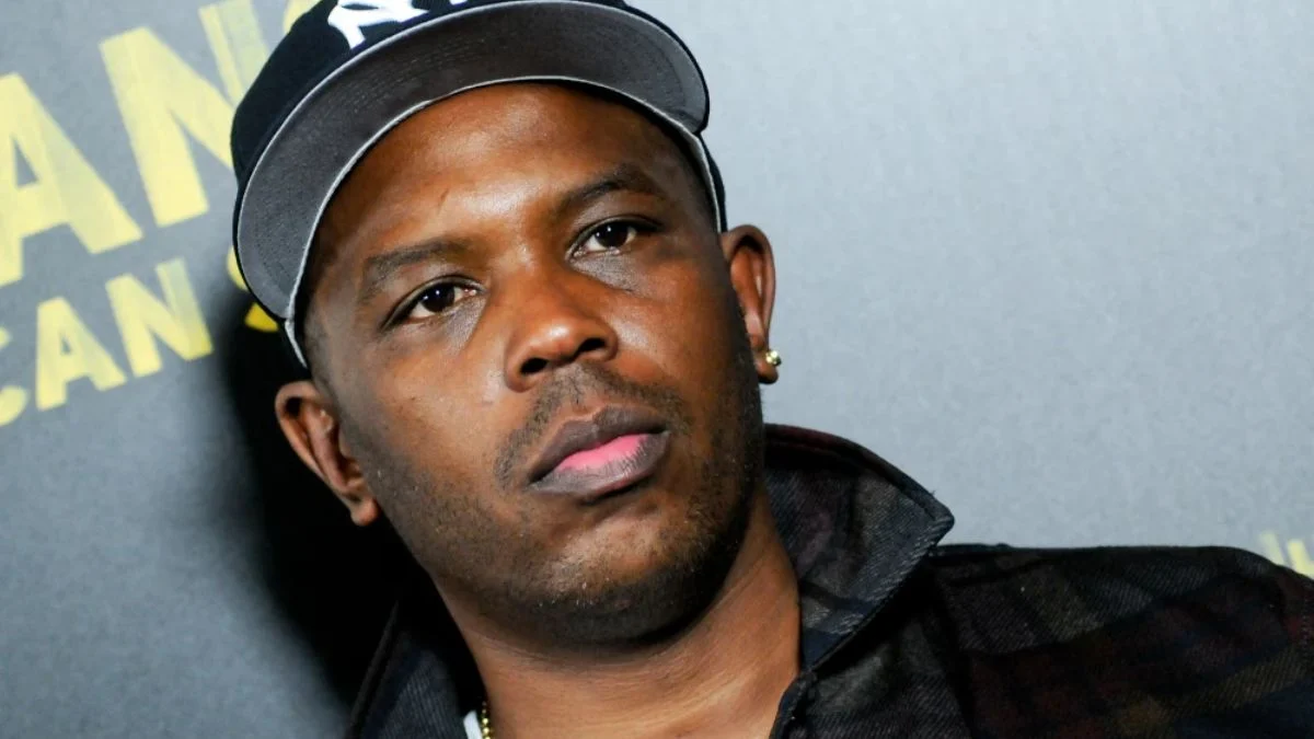 A close-up portrait of Oliver “Power” Grant wearing a black New York Yankees baseball cap and a dark jacket.