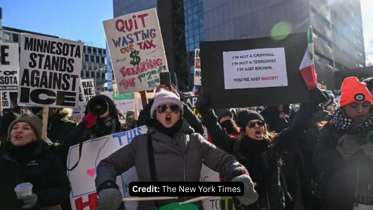 Protesters holding signs that read "Minnesota Stands Against ICE" and "I’m Not a Criminal, I’m Just Brown" during a march in downtown Minneapolis.