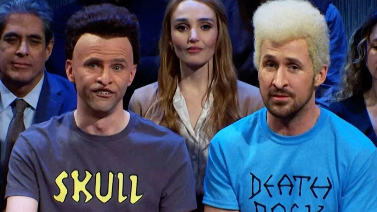 A vibrant purple and yellow Mardi Gras float with a giant smiling mask and green ribbon moving through a crowded New Orleans street at night.