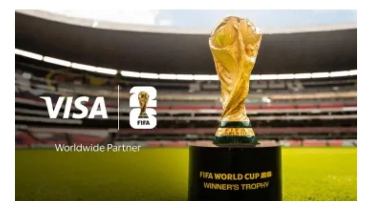 FIFA World Cup Winner's Trophy on a pedestal at a stadium with Visa Worldwide Partner branding for 2026 ticket presale.