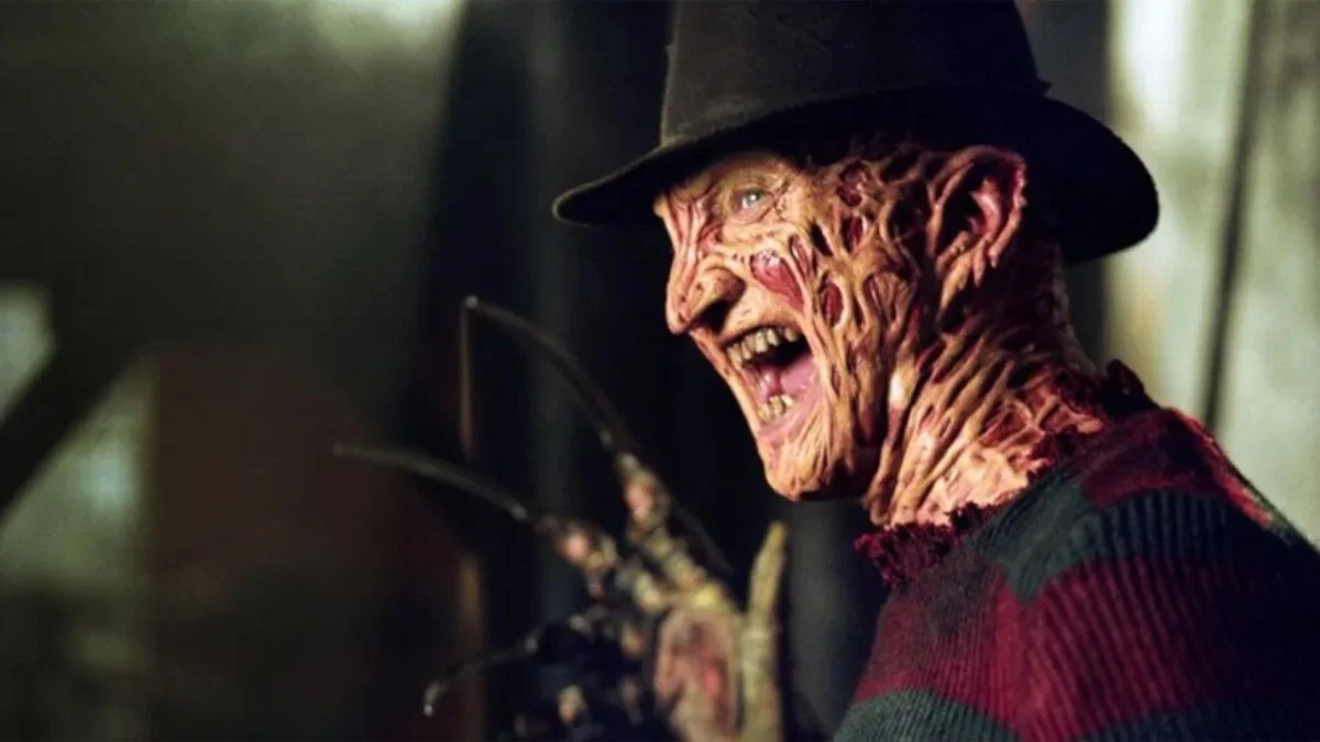 A close-up profile of Freddy Krueger laughing, showcasing his burnt skin and iconic fedora.