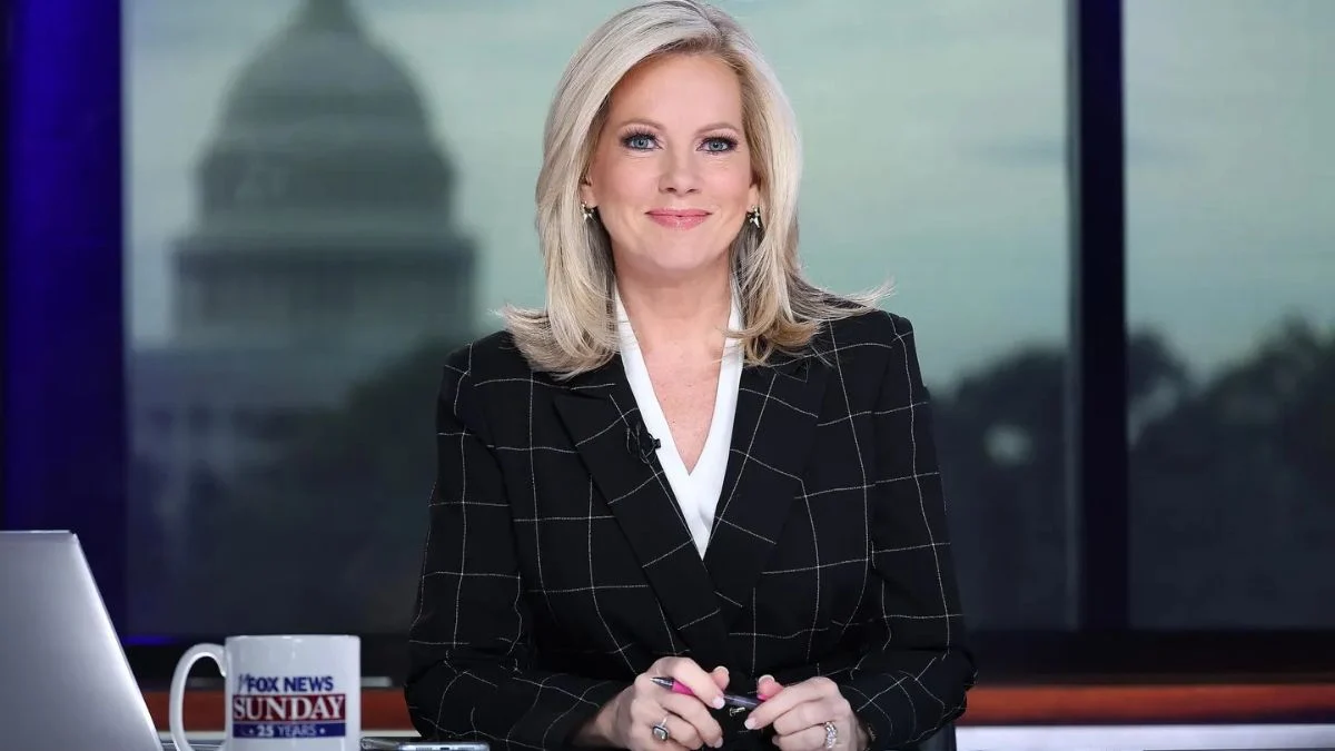 Fox News Sunday anchor Shannon Bream sitting at her desk in a black checkered blazer with the U.S. Capitol building in the background.
