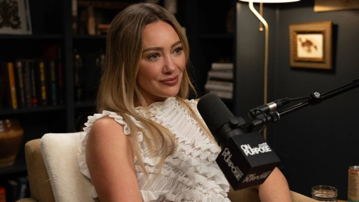 Hilary Duff appearing on the On Purpose with Jay Shetty podcast in a ruffled white top.