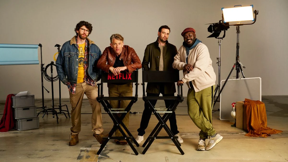 Creators and cast of Netflix comedy series Roosters posing in a studio set with film equipment.
