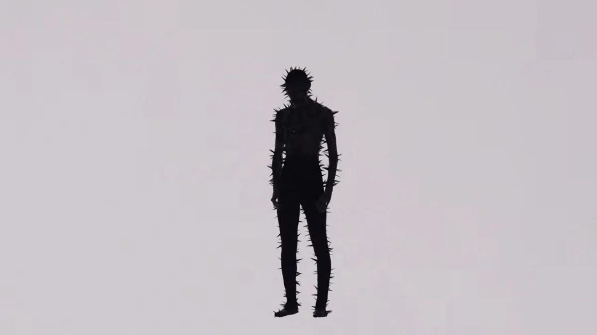 A dark silhouette of a TXT member covered in sharp thorns against a white background from the 7TH YEAR album teaser.