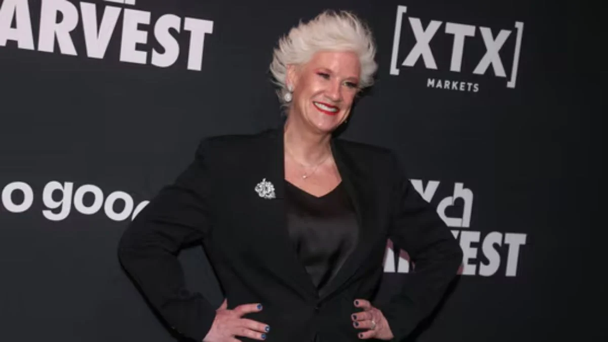 Anne Burrell posing in a black blazer at a City Harvest event before her final Wildcard Kitchen appearance.