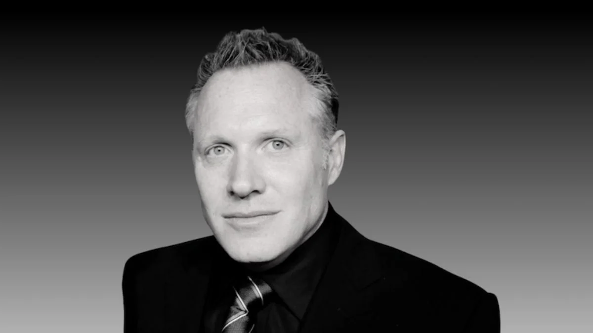 Andrew Gunn, Disney film producer of Freaky Friday and Cruella, in a black suit and striped tie.
