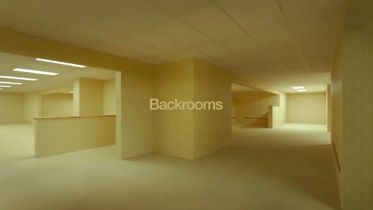 An empty, yellow-lit hallway with fluorescent lights and beige walls from the A24 Backrooms movie teaser.