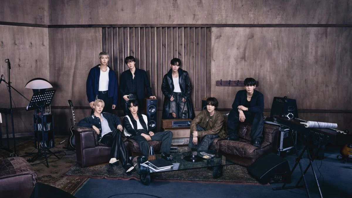 BTS members RM, Jin, SUGA, j-hope, Jimin, V, and Jungkook posing in a wood-paneled recording studio with vintage audio equipment.