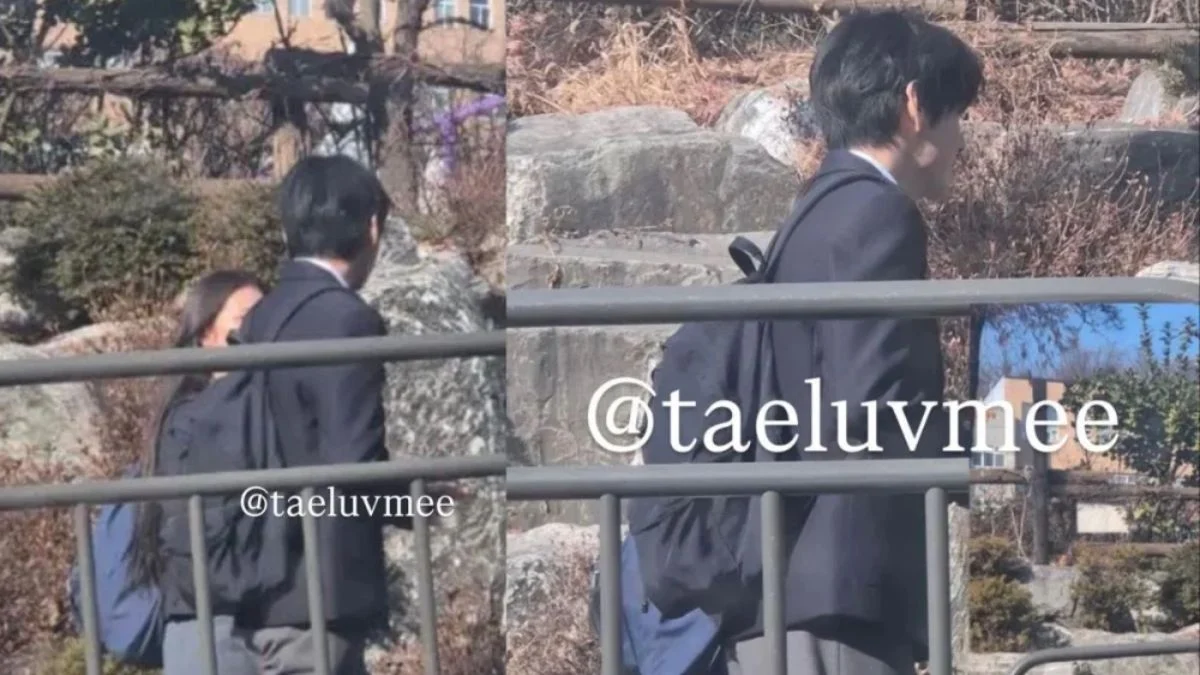 BTS member V (Kim Taehyung) from behind, wearing a black school blazer and backpack while filming at a Seoul girls' high school.