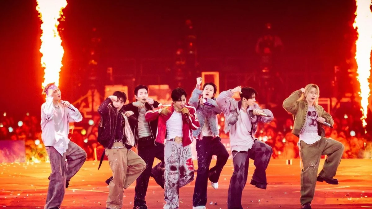 BTS performing high-energy choreography on stage with massive fire pyrotechnics in the background.