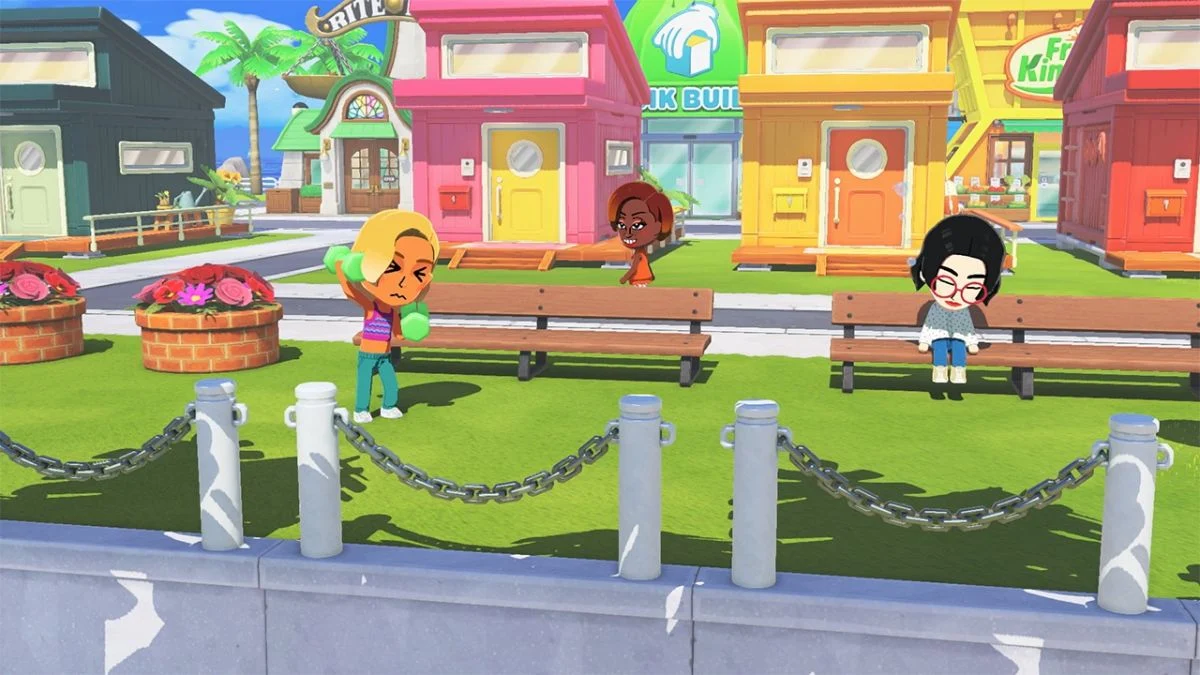 Multiple Mii characters on a grassy island area in Tomodachi Life: Living the Dream with colorful houses in the background.