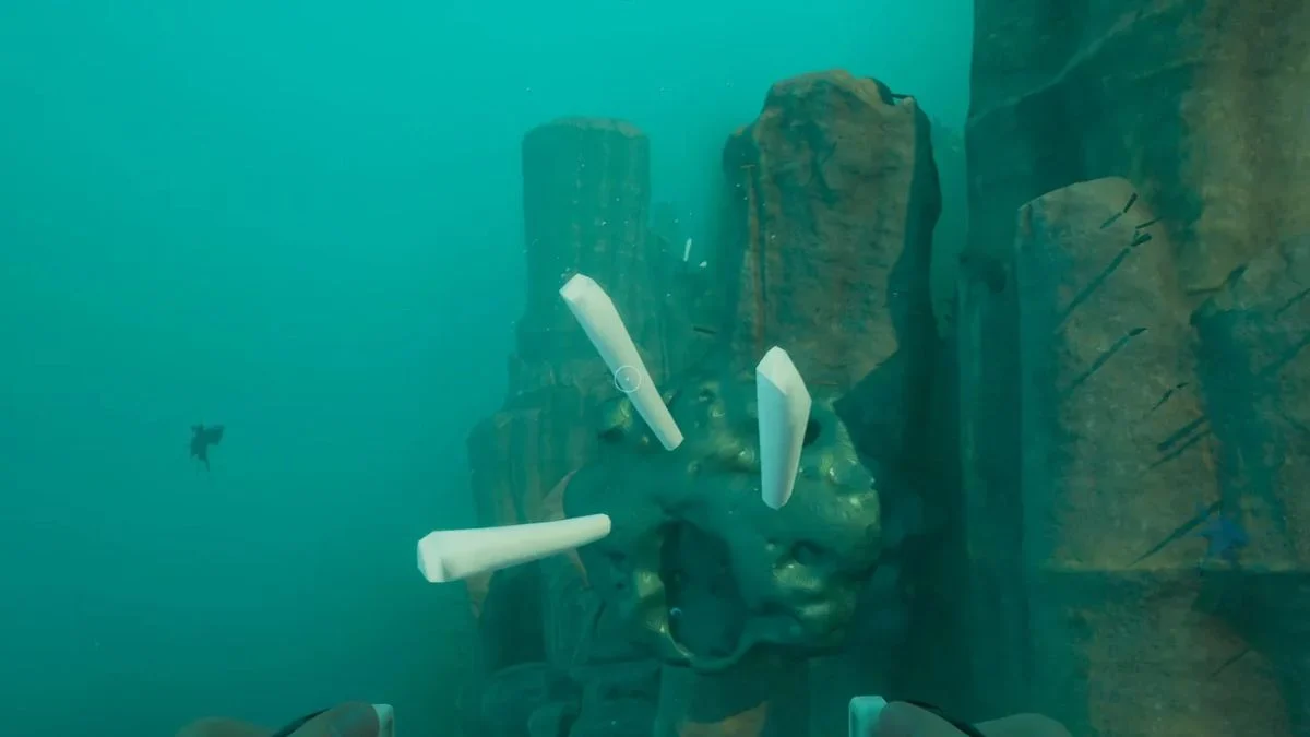 Subnautica 2 gameplay screenshot showing a player harvesting white tubular Creature Enamel deposits from a cliff face underwater.