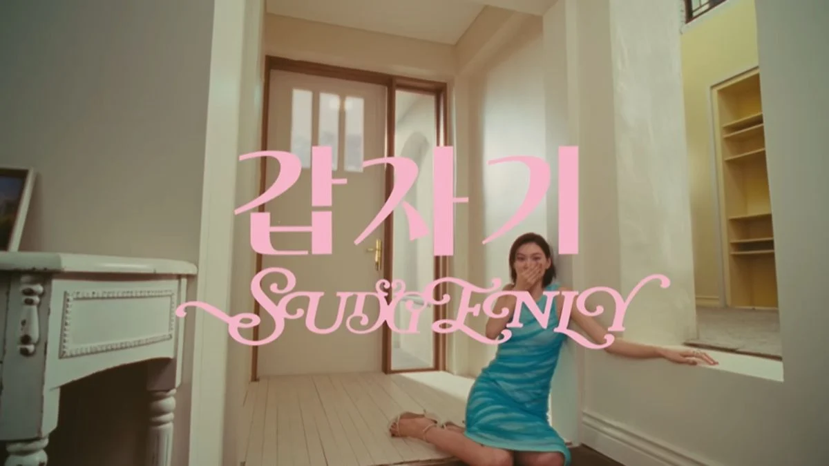 Kim Doyeon sitting on the floor in shock with her hand over her mouth in the I.O.I Suddenly music video teaser.