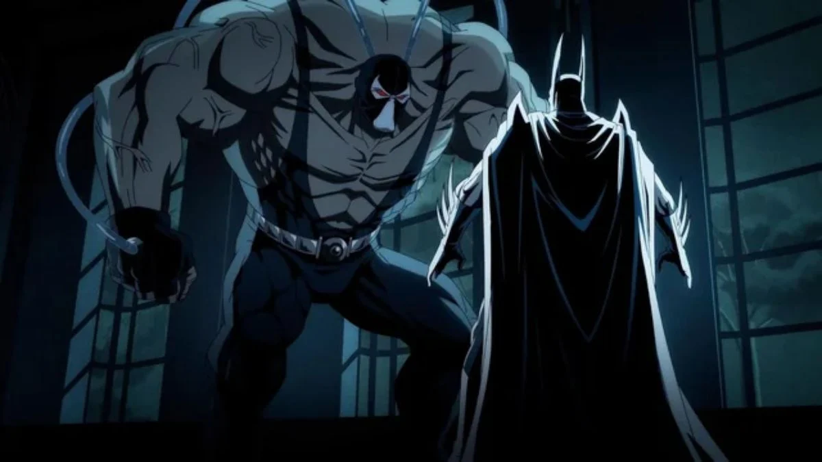 The massive villain Bane with venom tubes attached stands menacingly over Batman inside a dimly lit room.