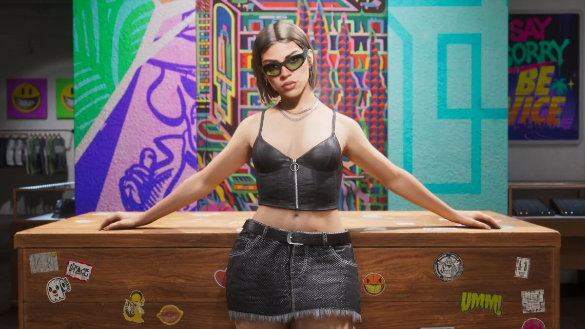 Theft Auto VI protagonist Lucia standing in a brightly decorated clothing store with graffiti and stickers on the counter, showcasing the game's official graphics.