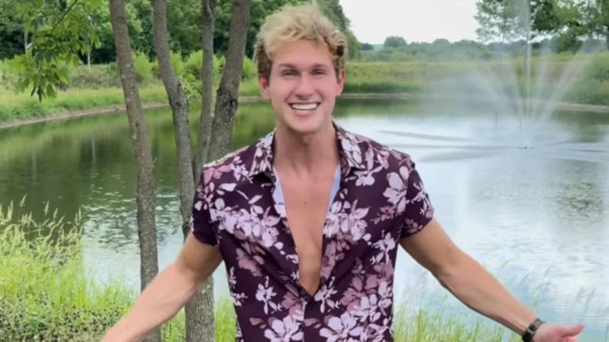 Levi Banks smiling with arms open in front of a pond in an Instagram video.
