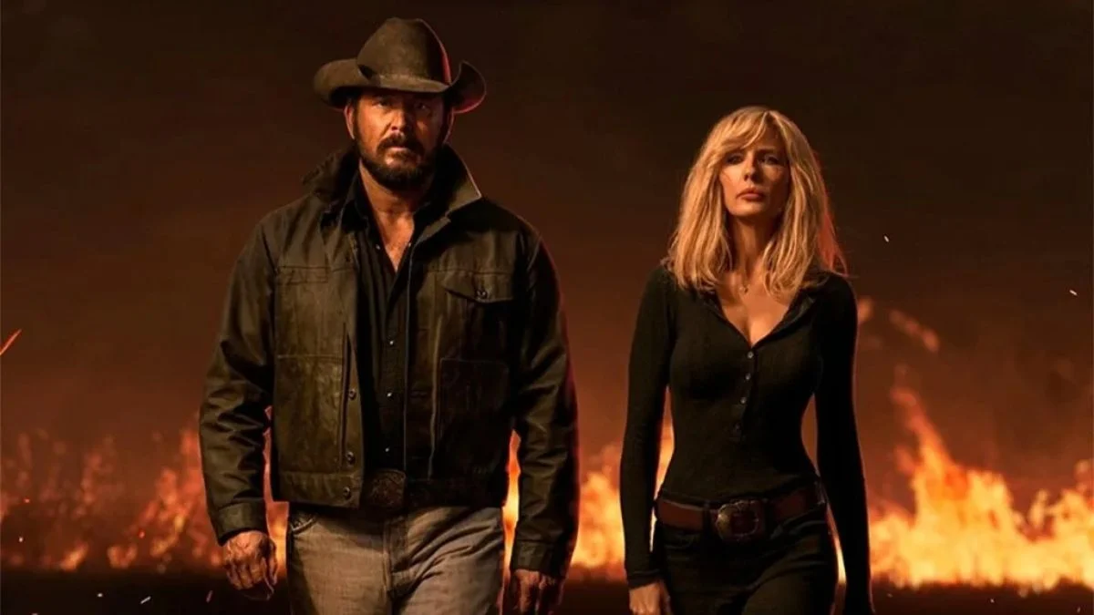 Cole Hauser as Rip Wheeler and Kelly Reilly as Beth Dutton walking with a serious expression against a background of blazing fire in Dutton Ranch.