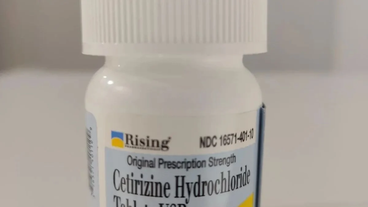 Close-up shot of a white plastic medicine bottle featuring a Rising Pharma Holdings label for Cetirizine Hydrochloride Tablets USP 5 mg with National Drug Code NDC 16571-401-10.