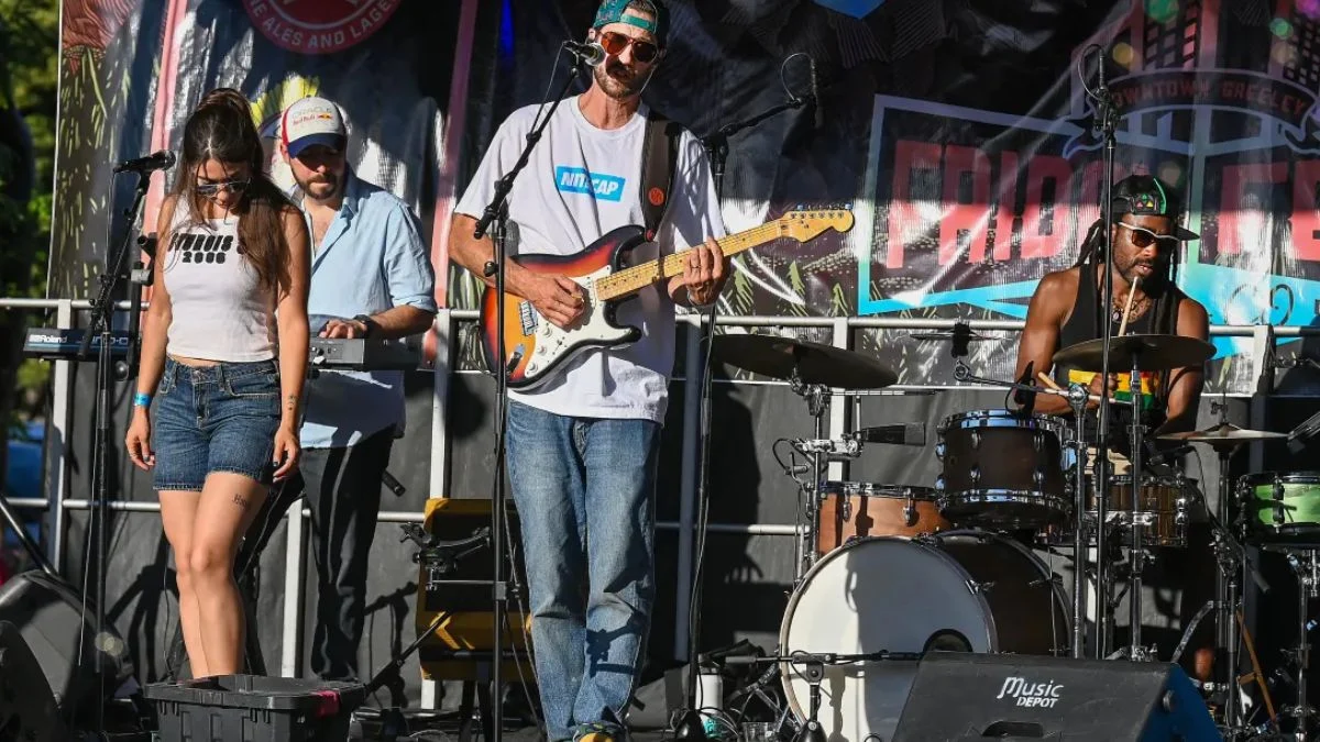 Live musical band performing on the outdoor stage at Friday Fest 2026 in Downtown Greeley with a guitarist, drummer, keyboardist, and singer.