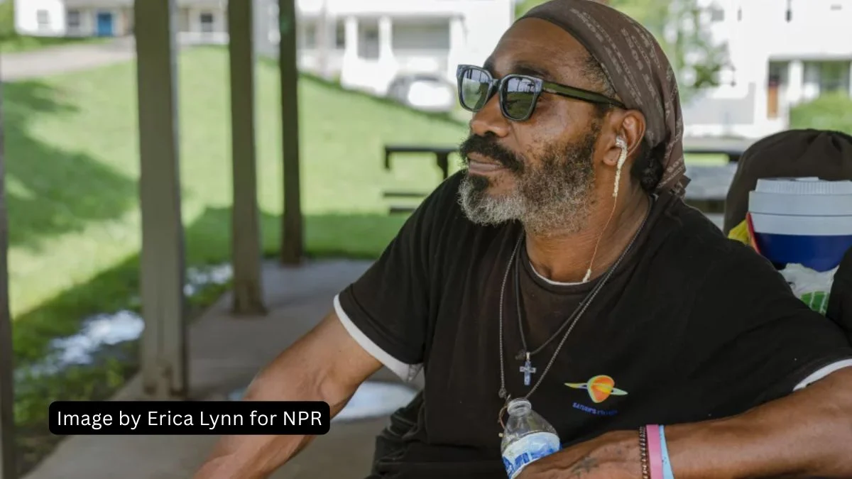 Close-up portrait of Joseph Lamont Williams wearing sunglasses and a headscarf, sitting under a park pavilion in East Nashville.