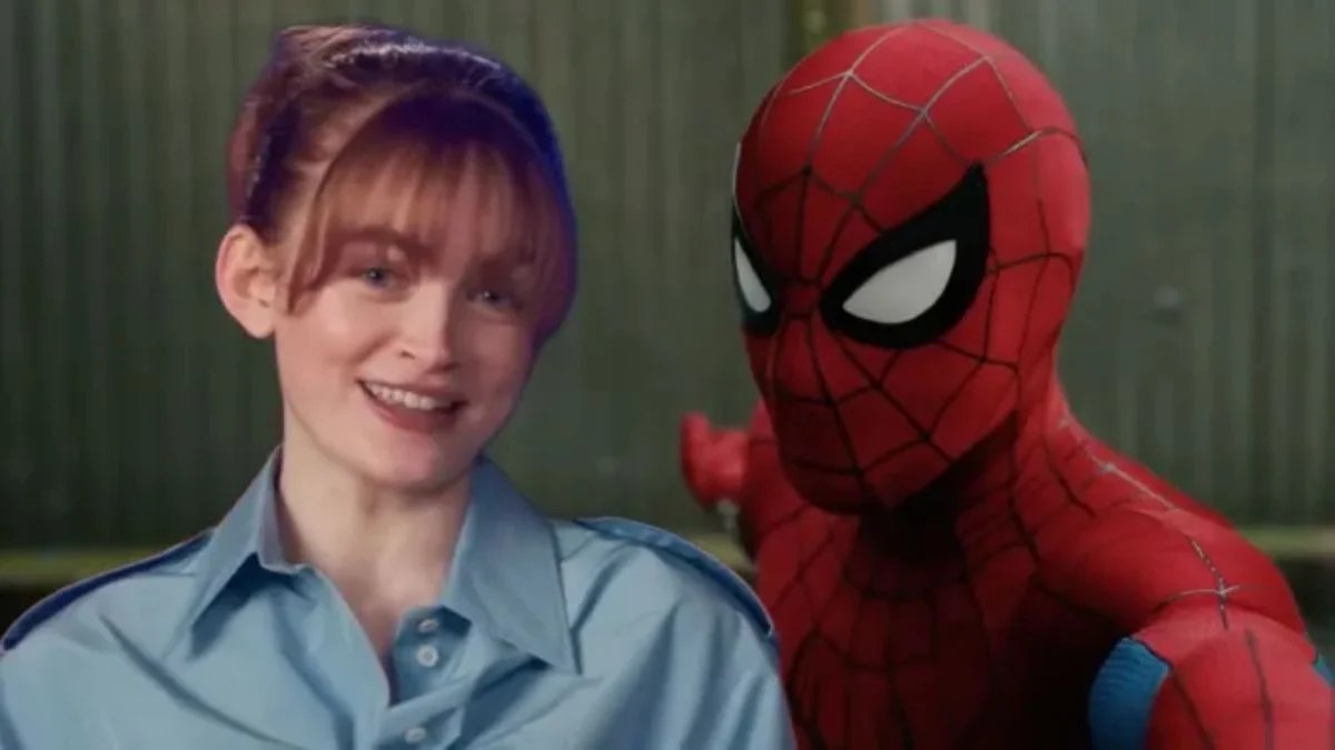 Sadie Sink with her hair tied up in a light blue button-down shirt smiling next to Spider-Man in his classic red and blue suit.