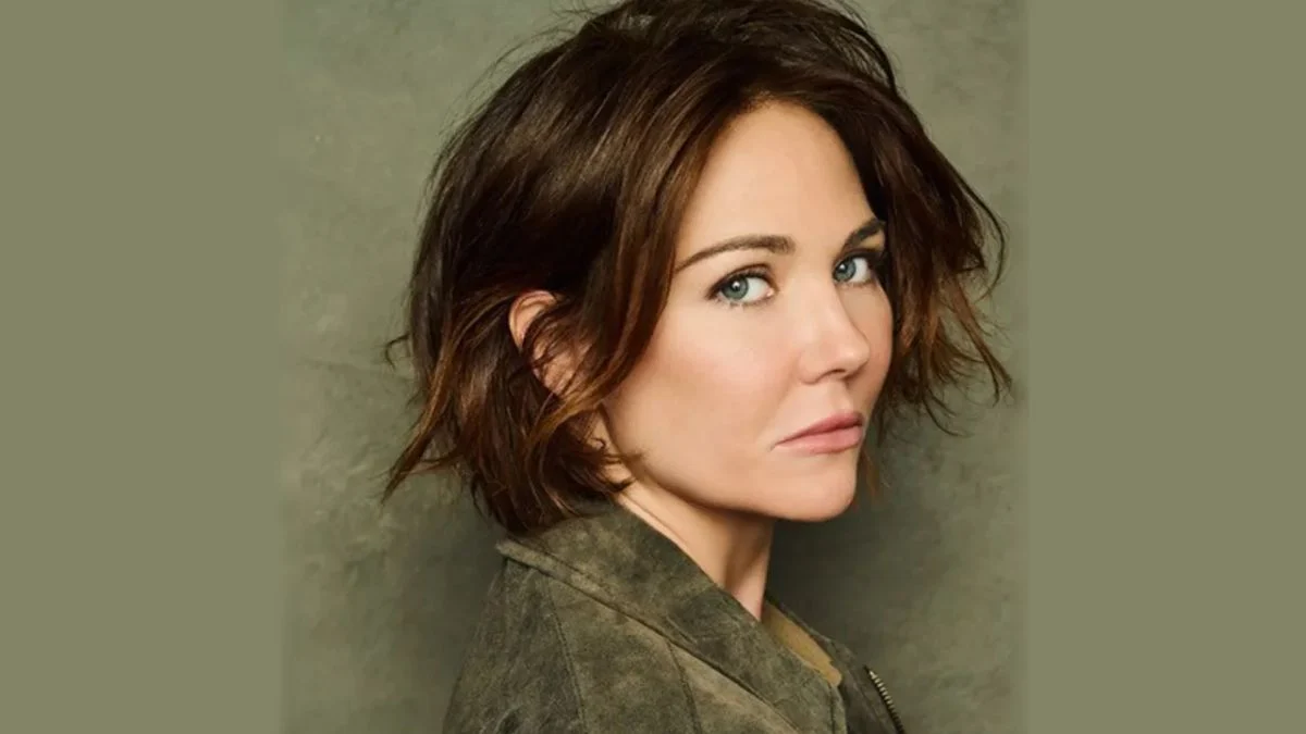 Studio profile headshot of actress Jade Harlow with short brown hair looking directly at the camera while wearing a green jacket.