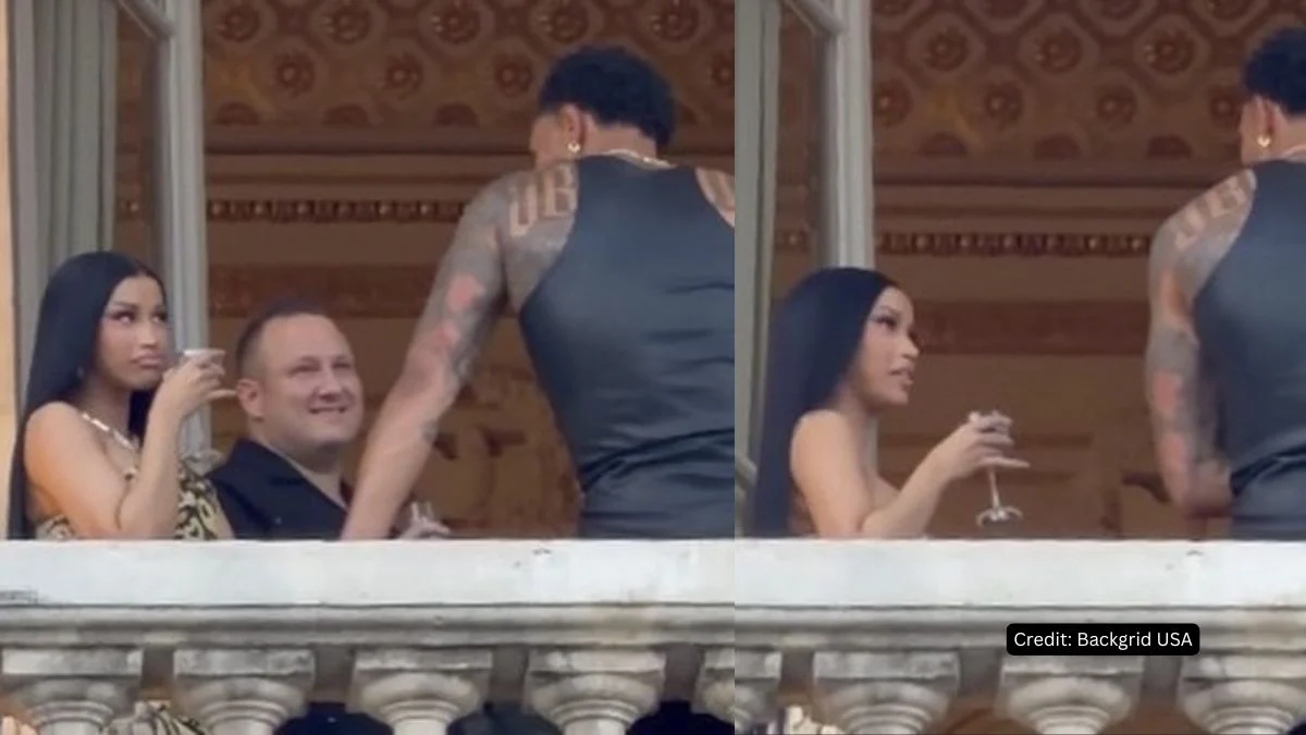 Cardi B holding a drink while talking to Maduka Okoye on a balcony during Paris Fashion Week