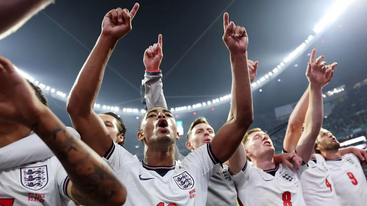 Jude Bellingham and England football players singing Wonderwall with arms raised in celebration during the 2026 FIFA World Cup.