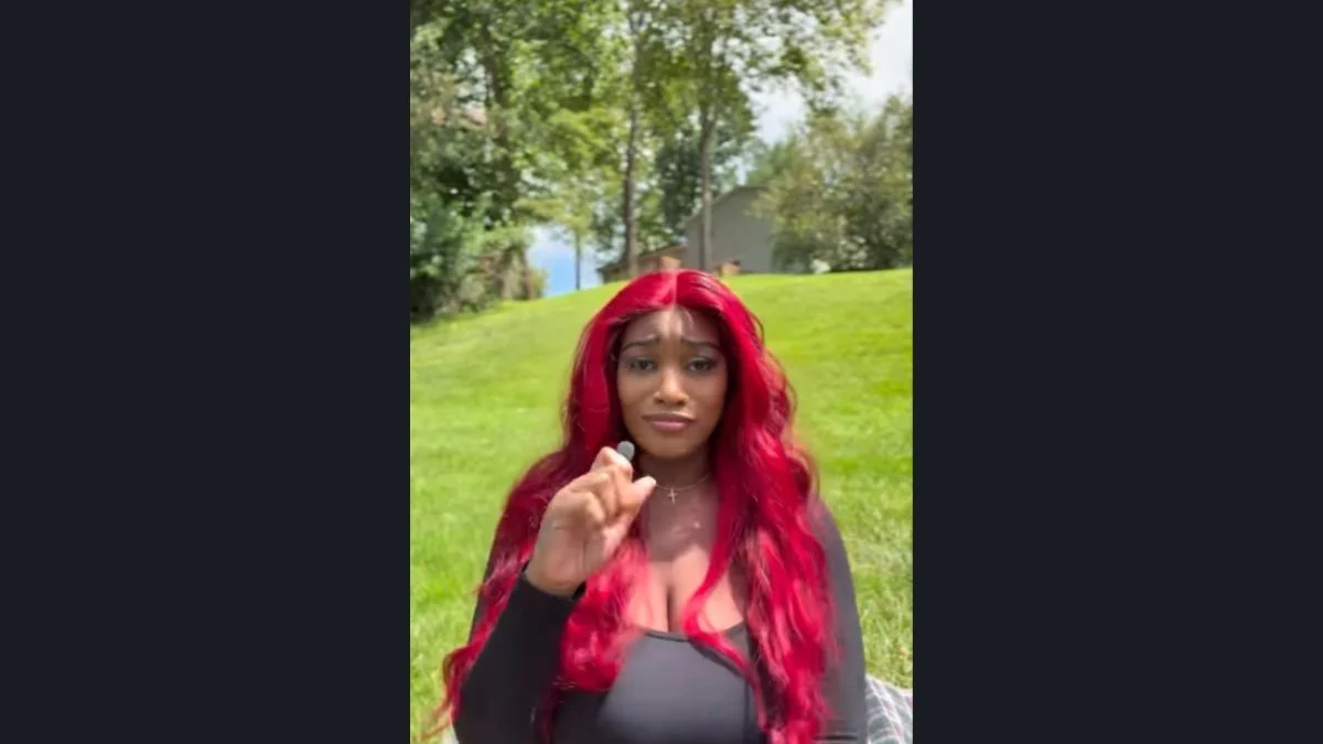 Ntsako Sako Mathivha with vibrant red hair addressing the camera outdoors