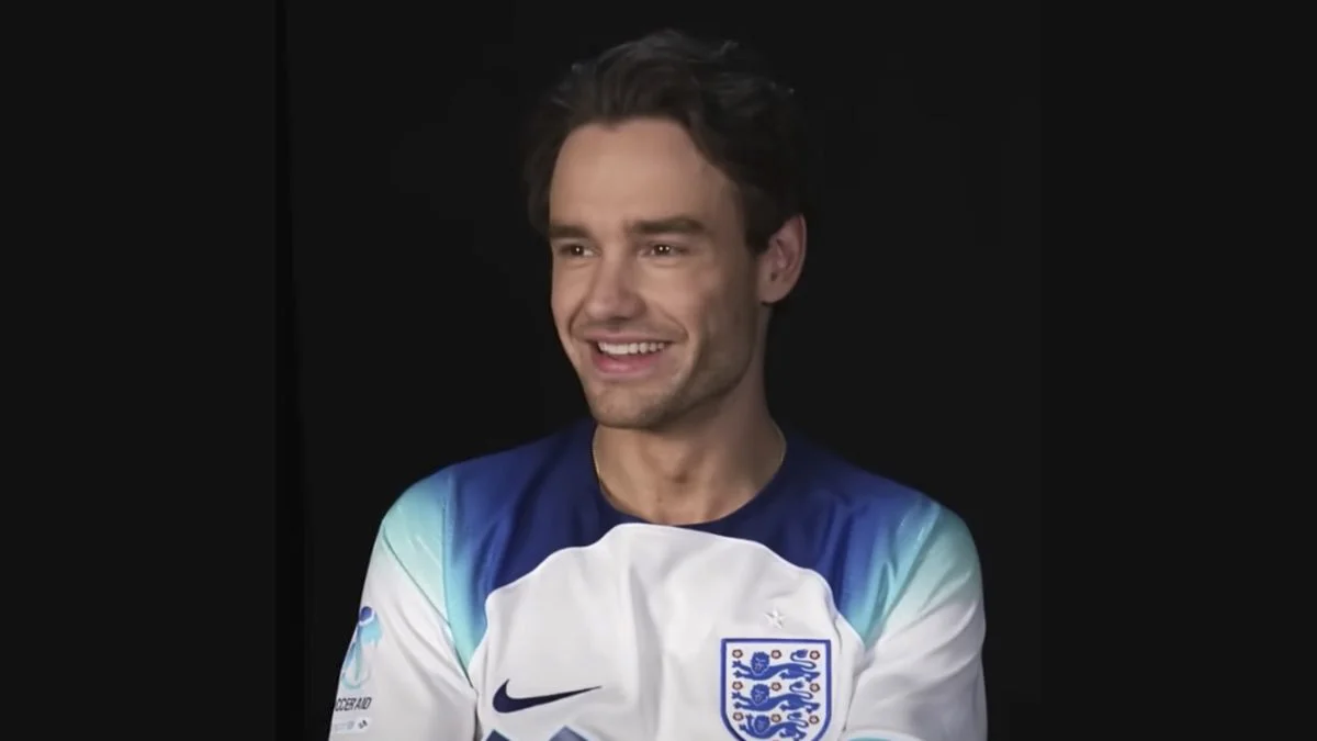 Liam Payne smiling during a Soccer Aid interview setup in an England football shirt.