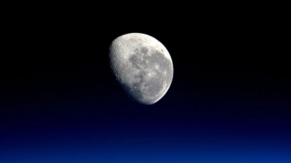 Full view of the Moon suspended in the darkness of deep space above Earth's atmosphere.