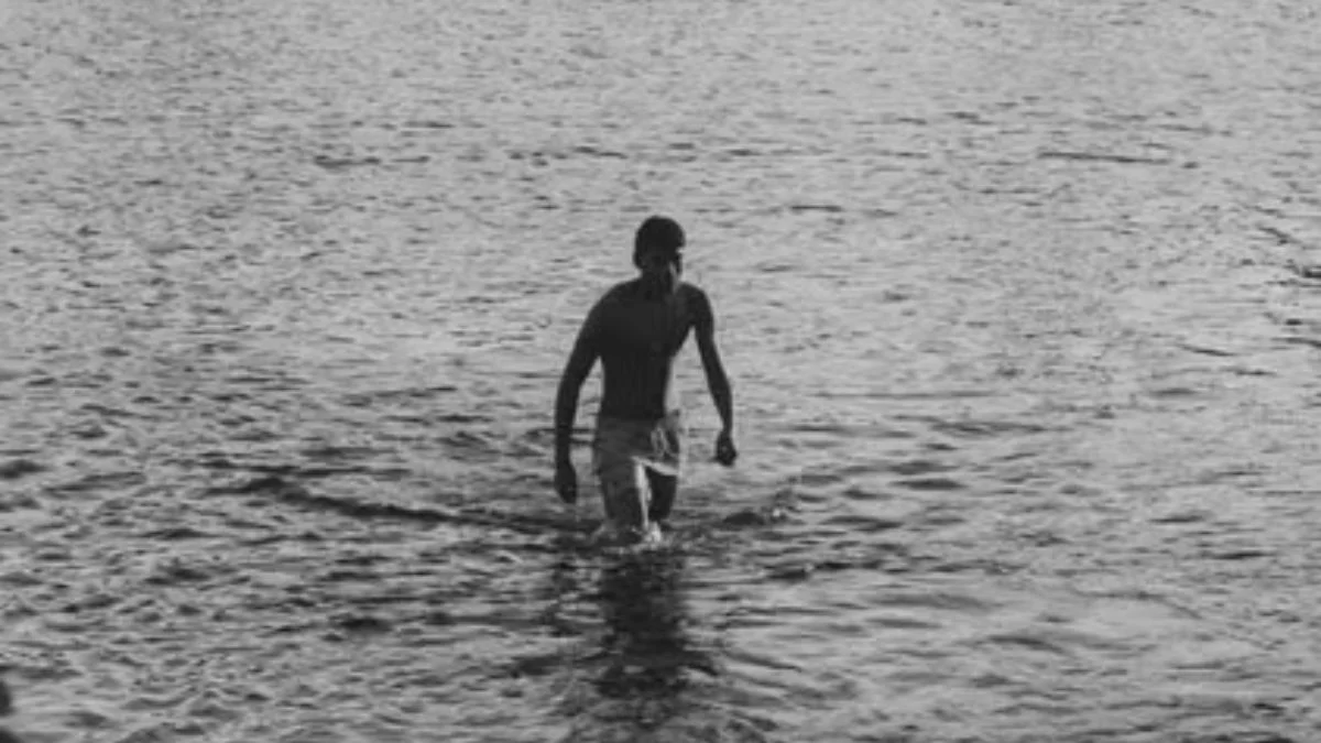 Silhouette of a teenager wading in water representing Iqbal Sheikh's rare condition